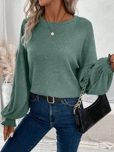 Detail of a casual green ribbed long-sleeved t-shirt styled with jeans and a handbag