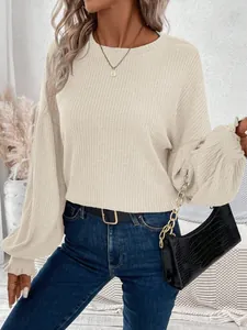 Close-up detail of cream ribbed knit long sleeve top showing the soft textured fabric
