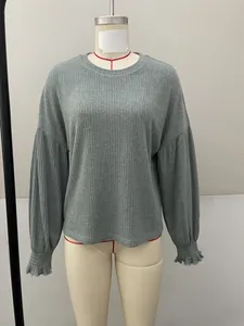 Close-up of a grey ribbed round neck long-sleeve top with ruffled cuffs on mannequin