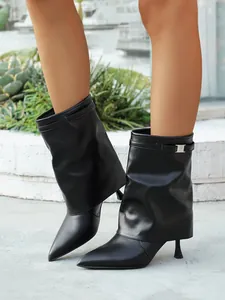 Detail view of black pointed toe stiletto boots with a stylish fold-over shaft design.