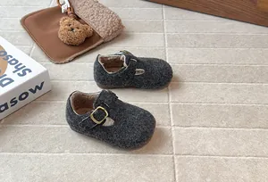 Detailaufnahme der grauen Kinderfilzschuhe mit warmem Fleecefutter und goldener Schnalle.