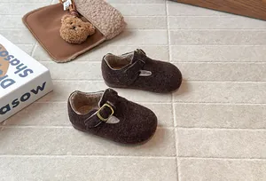 Nahaufnahme von braunen Wollfilz-Kinderschuhen mit warmem Fleecefutter und Metallschnalle