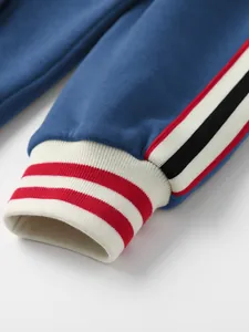Nahaufnahme der blauen Sweatshirt-Manschette mit rot-weiß gestreiftem Rippenmuster.