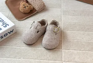 Nahaufnahme von Vintage-Filzschuhen für Kinder mit warmem Fleecefutter und Metallschnalle