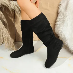 A detailed visual view of stylish black suede mid-calf slouchy boots with pleated design