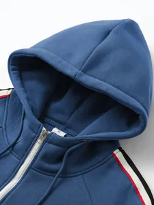 Detailansicht eines blauen Herren-Kapuzenpullovers mit rot-weißen Streifen an den Schultern.