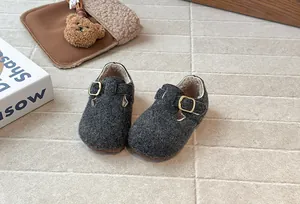 Nahaufnahme der kuscheligen grauen Filzschuhe für Kinder mit warmem Fleecefutter und Schnalle.