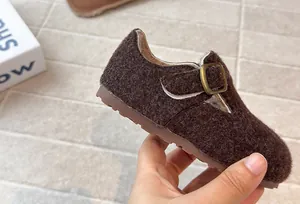 Detail von Kinder-Filzclogs mit Wolltextur und Metallschnalle für den Winter