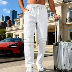 Dettaglio dei pantaloni in lino bianco traspirante da uomo con ginocchia pieghettate.