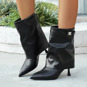 Black pointed-toe pant-leg boots with thin heels for women in a stylish outdoor setting