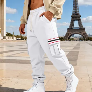 Close-up view of white men's cargo sweatpants featuring a striped pocket and cuffed hem