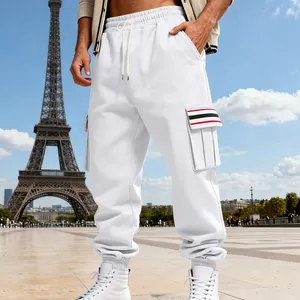 White men's fleece cargo pants with striped pocket detail standing in front of Eiffel Tower