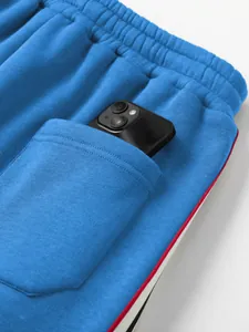 Detailansicht der blauen Baumwoll-Jogginghosentasche mit Handy und Seitenstreifen