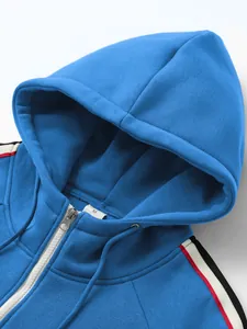 Detailansicht eines blauen Kapuzenpullovers mit kontrastierenden Streifen an den Schultern