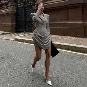 Side view of an elegant grey deep V-neck blazer dress with detailed draped skirt