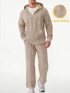 Detail of beige men's cable knit hoodie showing the intricate jacquard pattern texture.