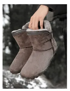 Close-up of brown suede snow boots with warm faux fur lining and buckle detail.