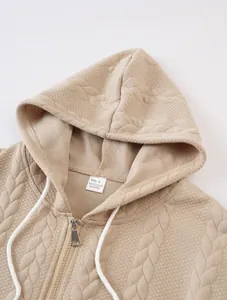 Macro detail of beige jacquard textured hooded sweatshirt with white drawstrings