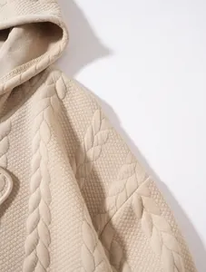 Close-up detail of beige jacquard textured fabric on a casual men's hoodie garment