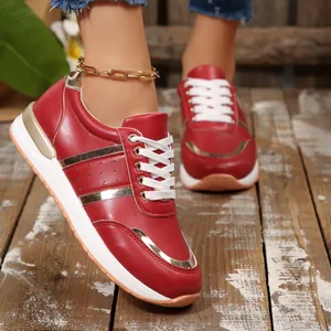 Vista dettagliata di eleganti scarpe da ginnastica rosse da donna con accenti dorati e suole