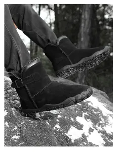 Detailed side view of black suede snow boots with buckle strap and anti-slip sole