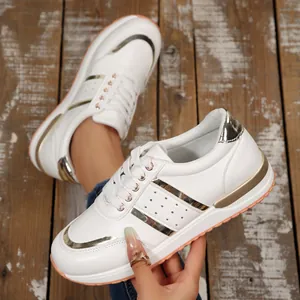 Primo piano di sneakers bianche da donna con platform e raffinati dettagli dorati