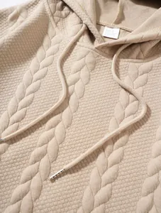 Detailed macro view of the beige cable knit jacquard pattern on a casual men's hoodie