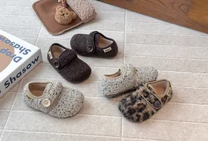 Macro view of cozy fleece-lined children's clogs in brown, leopard, and cream flecked styles.