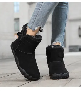 Detail shot of black suede wide-toe snow boots with non-slip sole and buckle accent.