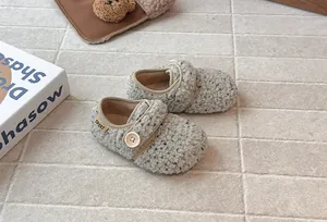 Close-up of girl's plush fleece Birkenstock shoes with stylish button detail