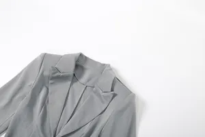 Close-up of grey blazer dress collar featuring a deep V-neck and notched lapels.
