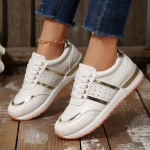 Primo piano delle sneaker platform bianche da donna con eleganti accenti dorati