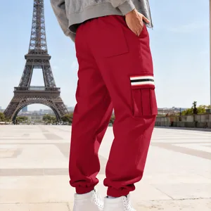 Detailed view of red men's cargo sweatpants with striped pocket in Paris setting