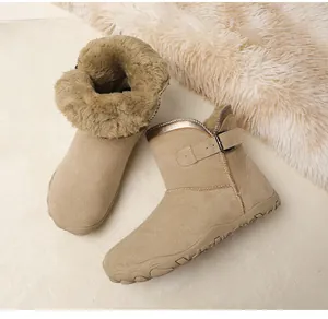 Close-up of warm tan suede snow boots with thick faux fur lining and buckle detail