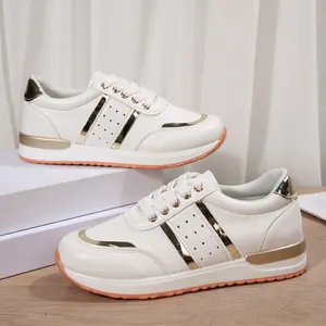 Dettaglio delle sneaker casual bianche da donna con eleganti accenti metallici oro.