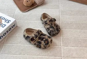 Close-up of leopard print toddler furry clogs with button detail and soft fleece lining.