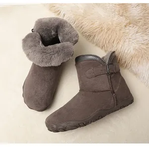 Detail of wide toe suede snow boots with thick faux fur lining and buckle.