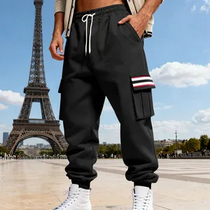 Close-up detail of black fleece cargo pants with striped pocket flap and drawstring waist