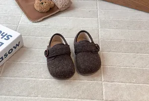 Cozy brown fuzzy toddler shoes with button strap and soft plush lining detail