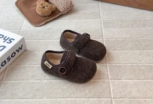 Close-up of warm brown fuzzy girls' shoes with stylish button detail.
