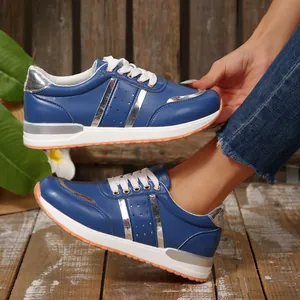 Vista dettagliata di sneaker blu da donna con suola bianca spessa e dettagli in argento