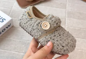 Close-up detail of warm fleece children's shoe with decorative button and soft lining