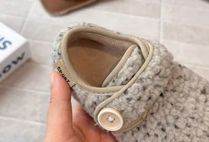 Close-up detail of girls' French style fuzzy button shoe with warm winter fleece lining