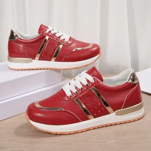 Vista dettagliata delle sneakers rosse e oro da donna con suola bianca spessa