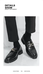 Gros plan de mocassins noirs pour hommes façon crocodile avec boucle dorée