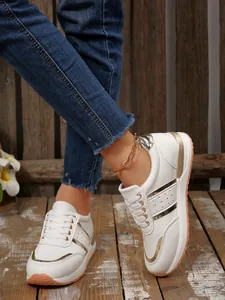 Eleganti sneakers bianche con dettagli metallici dorati indossate da una modella