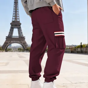 Men's burgundy fleece cargo sweatpants featuring a striped side pocket detail outdoors