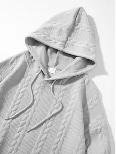 Close-up detail of grey men's jacquard hooded sweatshirt with cable knit texture