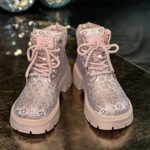 Close-up view of pink sparkling rhinestone-encrusted lace-up fashion Martin boots