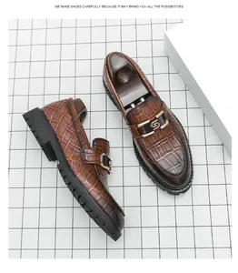 Détail de mocassins en cuir marron à motif crocodile pour hommes avec boucle dorée